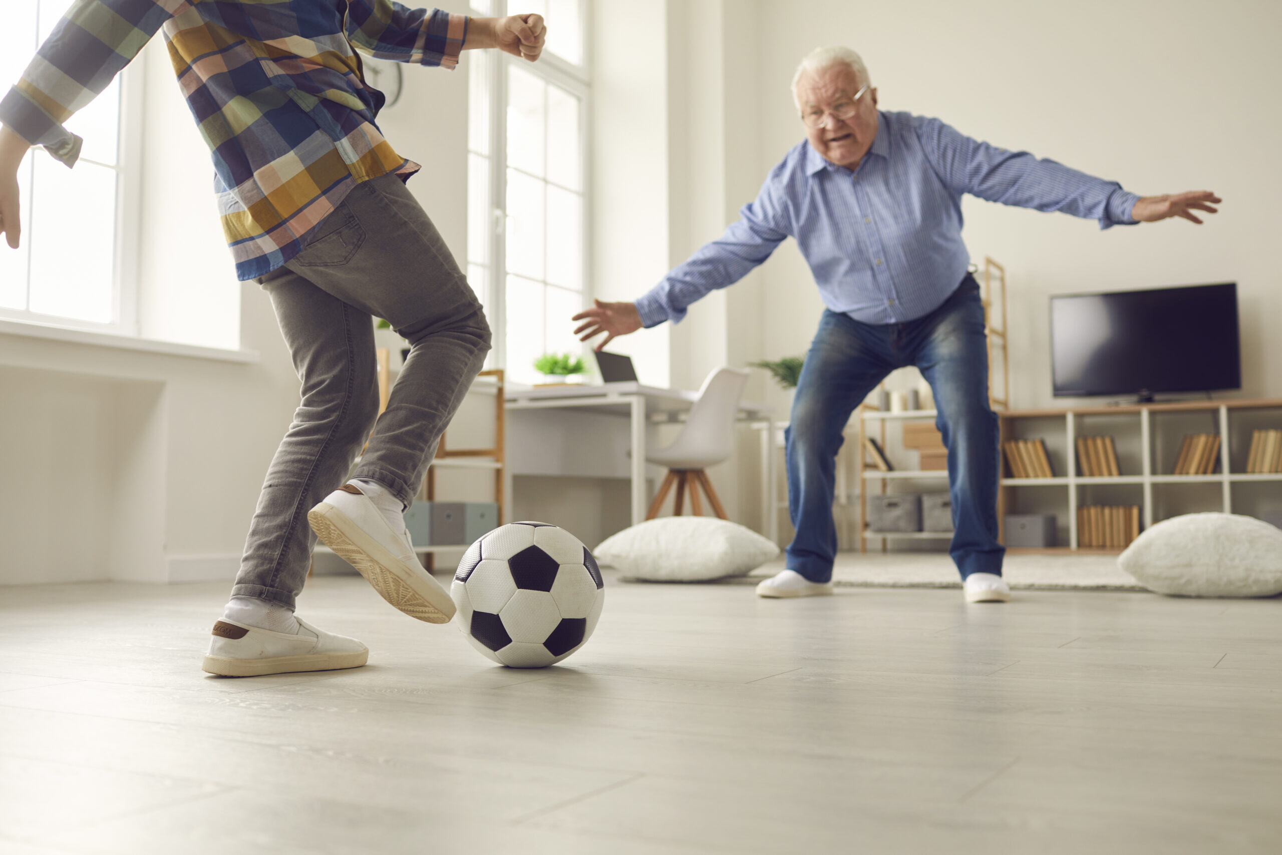Little Kid And His Grandpa Playing Soccer At Home And Having Fun Together Together